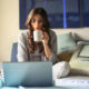 woman-in-bed-drinking-coffee-looking-at-homes-online